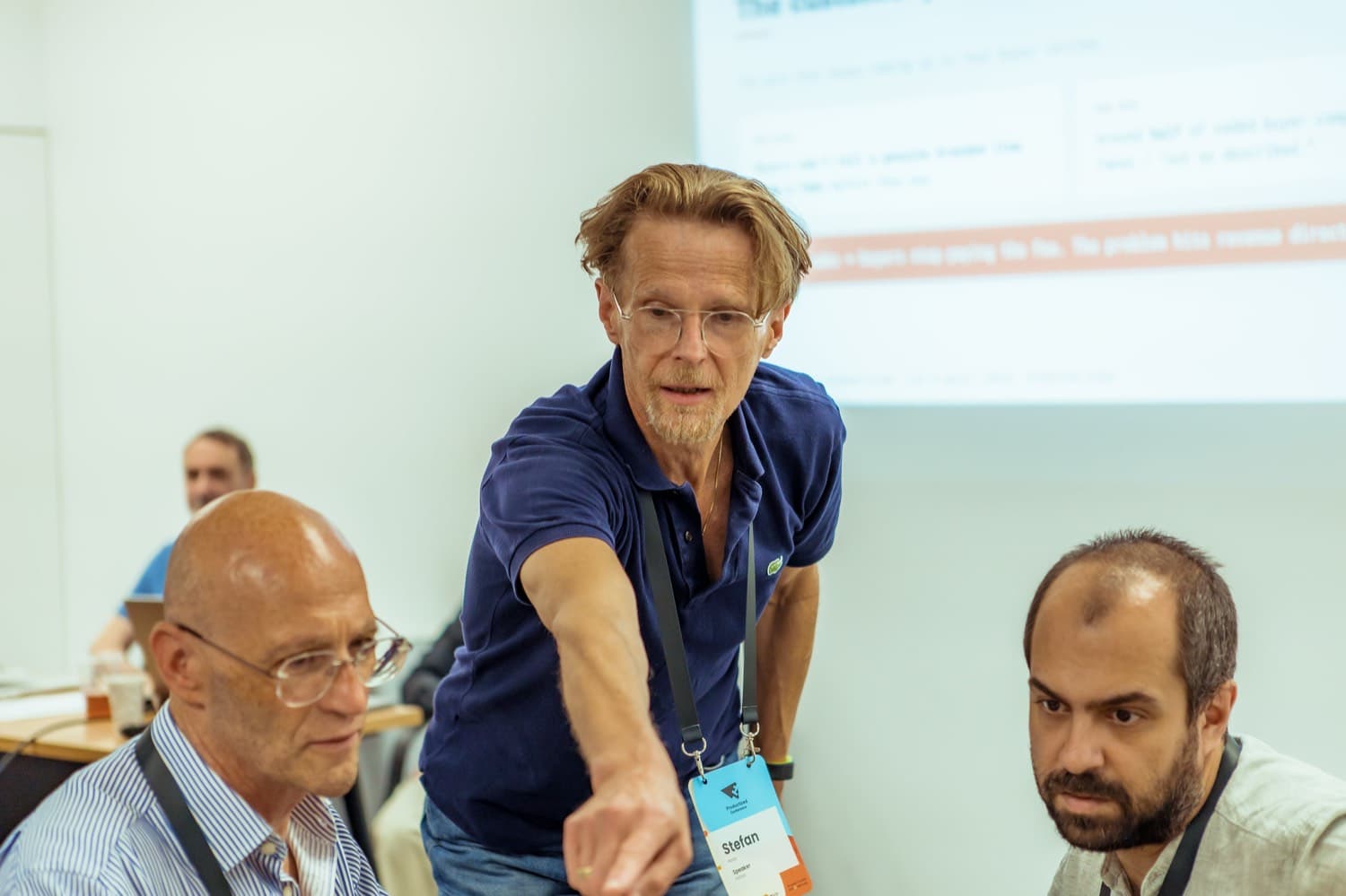 A podojo coach leaning in to guide two participants through a discovery exercise